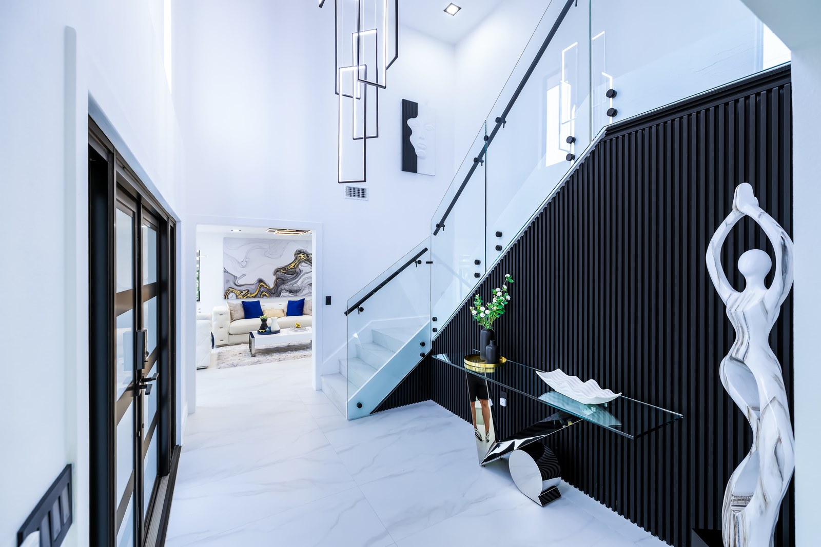 Designer entry with glass staircase and statement lighting