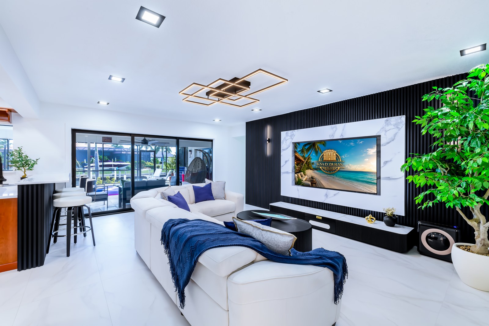 Family gathering room with sectional sofa, TV wall and pool view