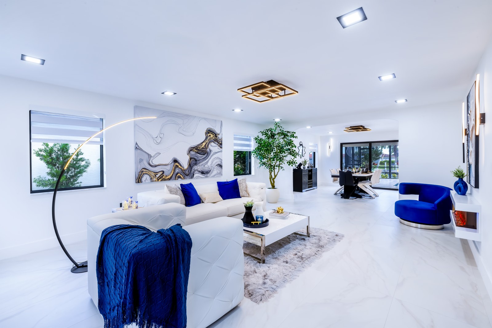 Soft living room with white sofas, royal blue accents and quiet light