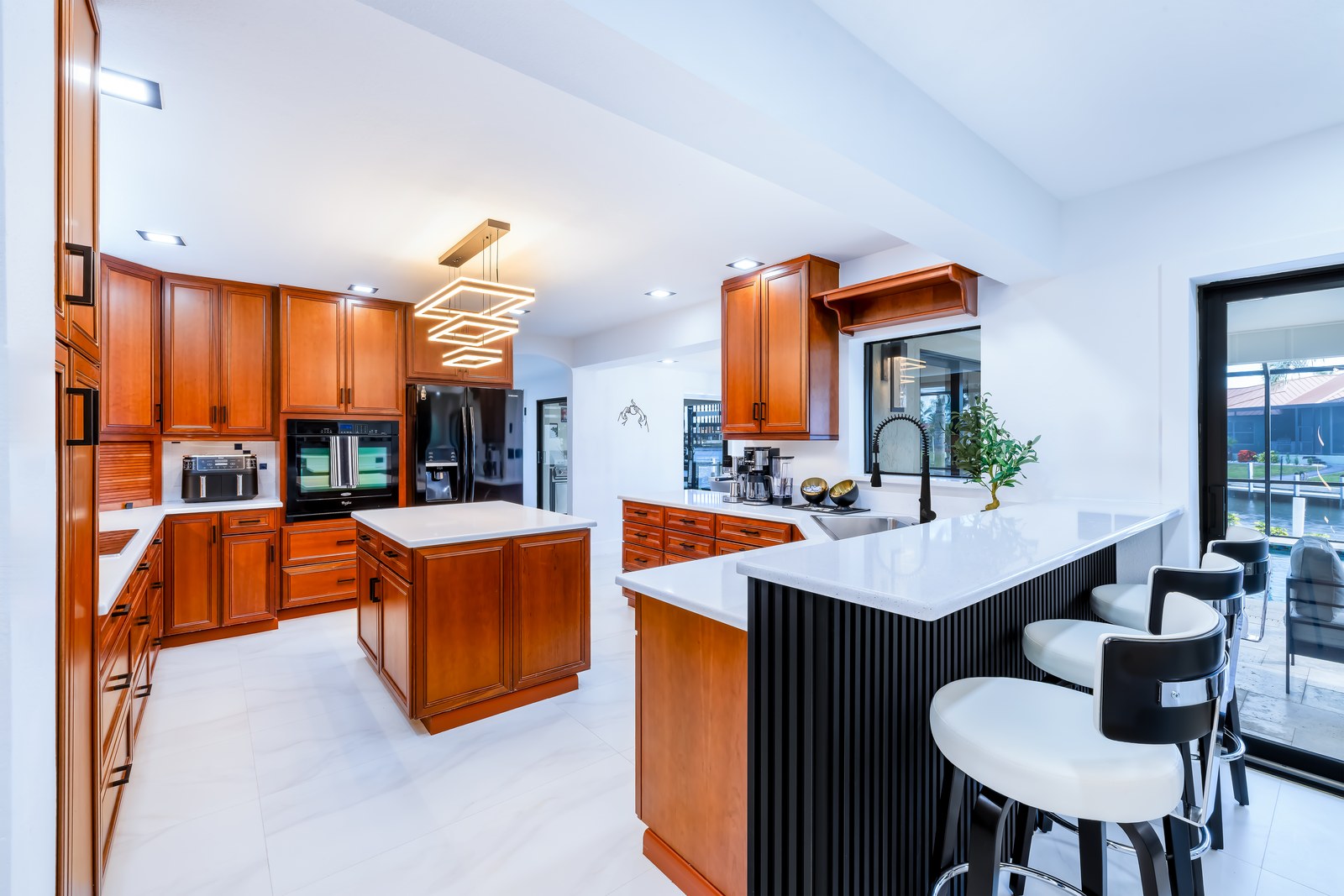 Chef kitchen with wood cabinets, white quartz and canal view